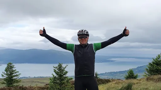 Cyclist on hilltop overlooking bay